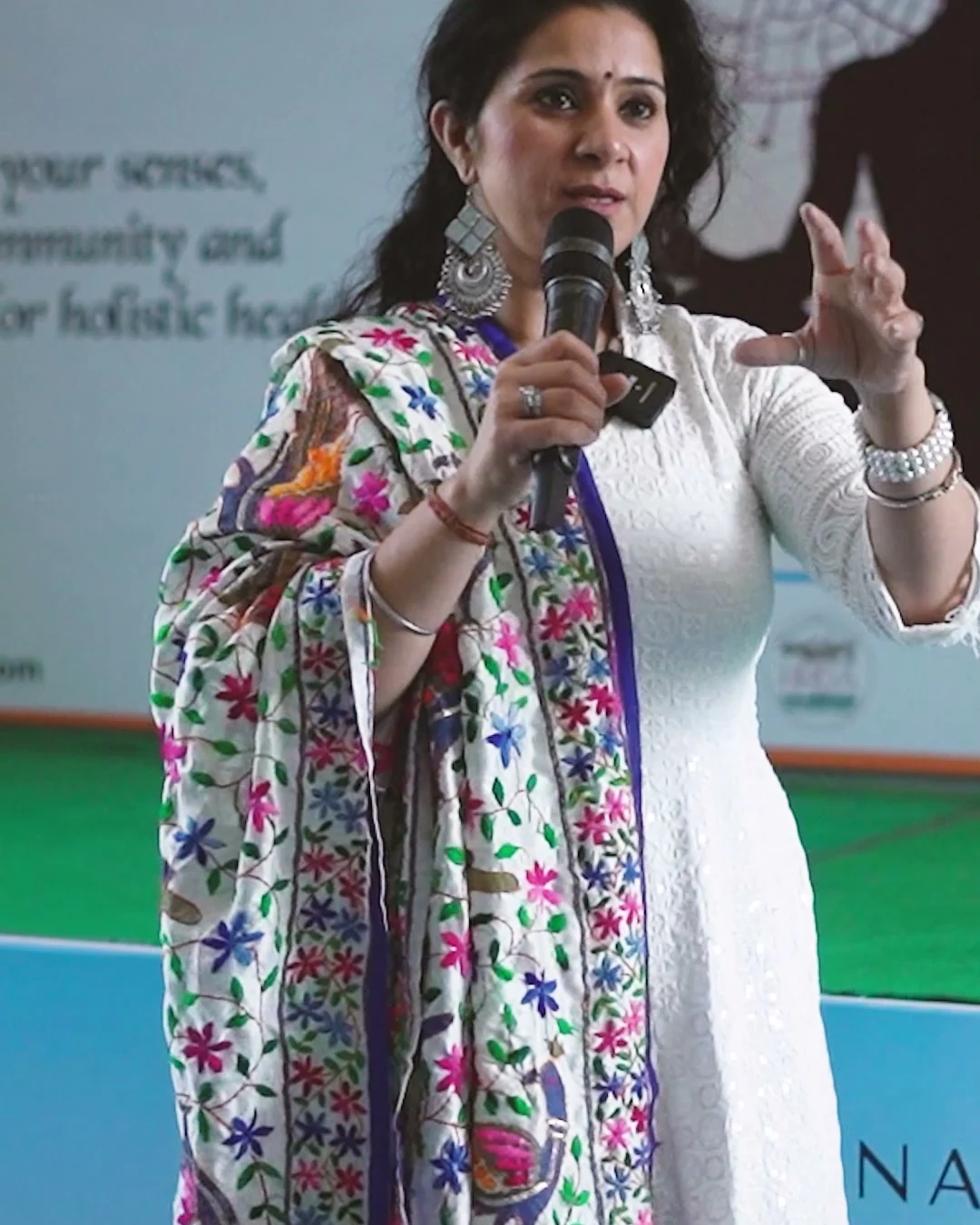 Charu Wadhwa taking a session with a microphone at the International Yog Festival 2025